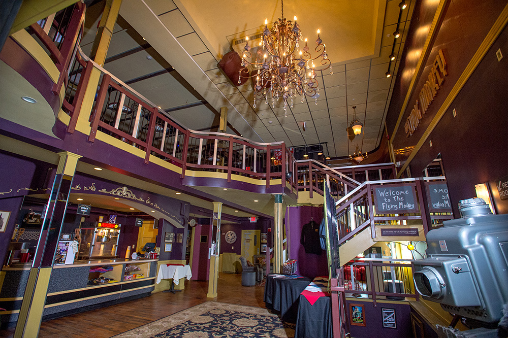 front lobby entry with chandelier in ceiling concession on left and balcony stairs on right