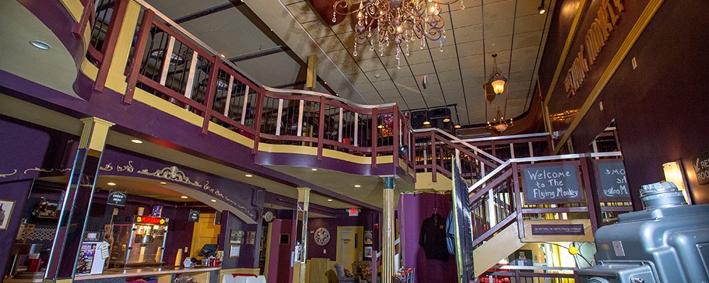 front lobby entry with chandelier in ceiling concession on left and balcony stairs on right