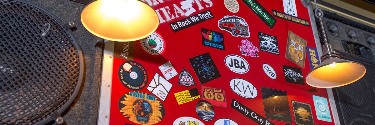 close up of band stickers on sound box above bar