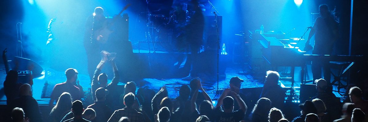 zach nugent performing on stage in front of a crowd lit in blue lights