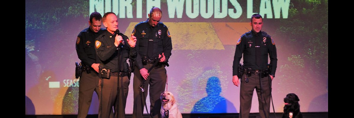 north woods law on stages with canines hosting an event